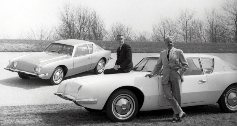 Raymond Loewy pose devant un modèle Studebaker qui affiche un design aérodynamique